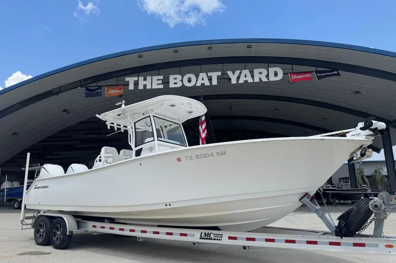 Slide: The Image of 2021 Sportsman Open 282 Center Console with dual outboard engines, docked on concrete. - 5