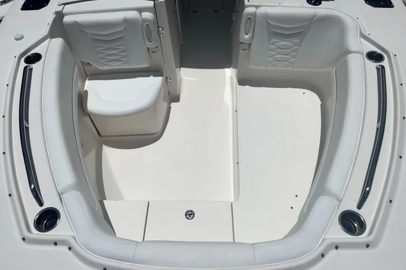 Slide: The Image of 2021 Robalo R317 Dual Console boat interior with white seating and cup holders. - 10