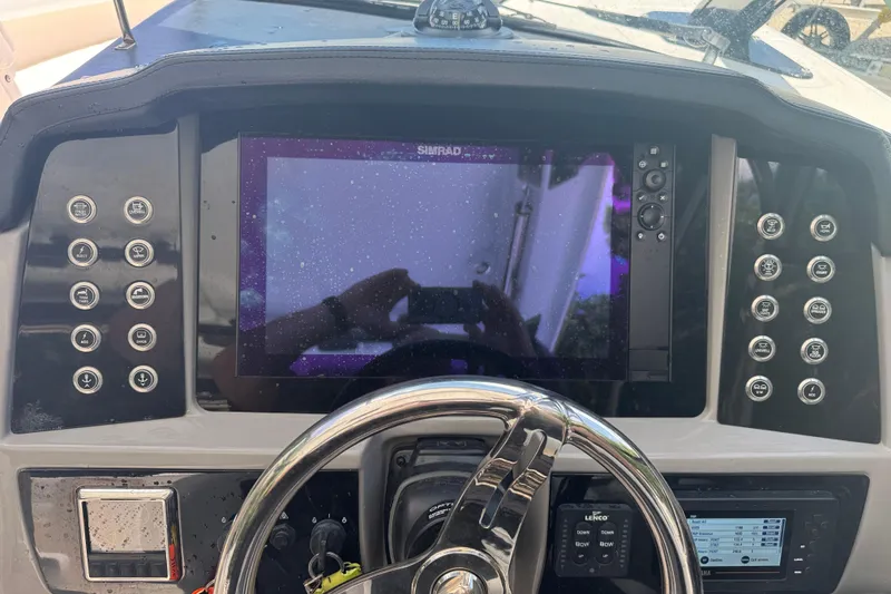 Slide: The Image of 2021 Robalo R317 Dual Console dashboard with Simrad display and control buttons. - 19