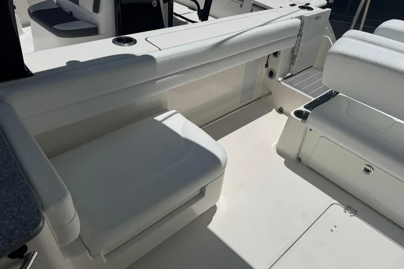 Slide: The Image of 2021 Robalo R317 Dual Console boat interior with white seating and cup holders. - 23