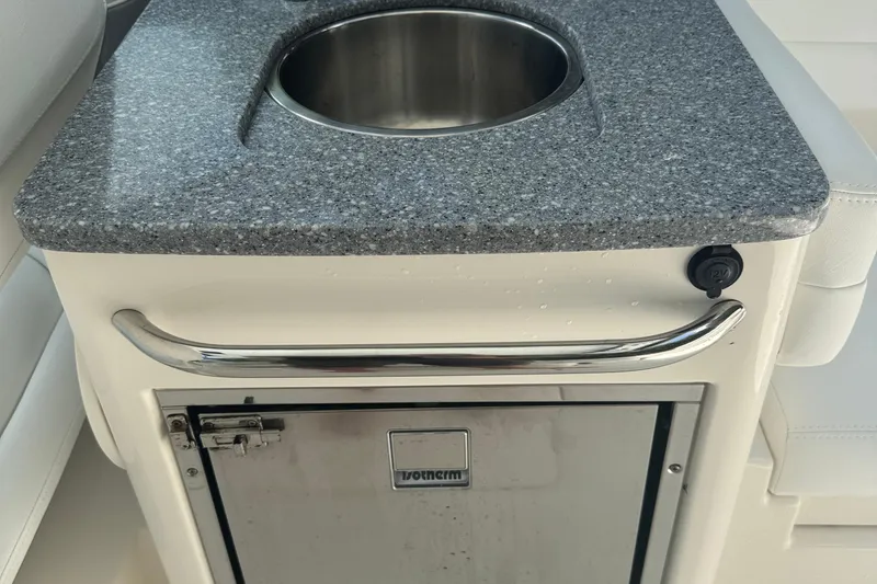 Slide: The Image of 2021 Robalo R317 Dual Console boat sink with granite countertop and storage compartment. - 24