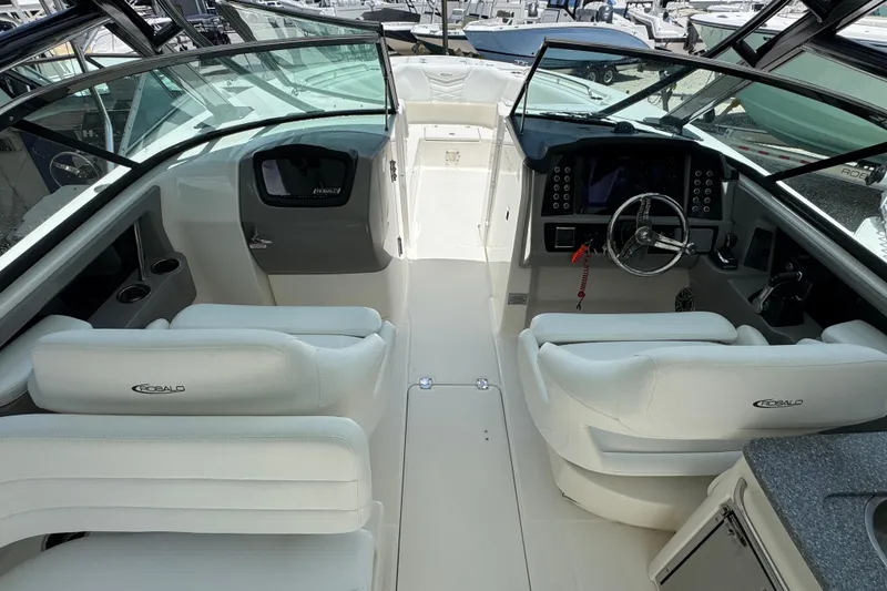 Slide: The Image of 2021 Robalo R317 Dual Console boat interior with white seating and modern dashboard. - 6
