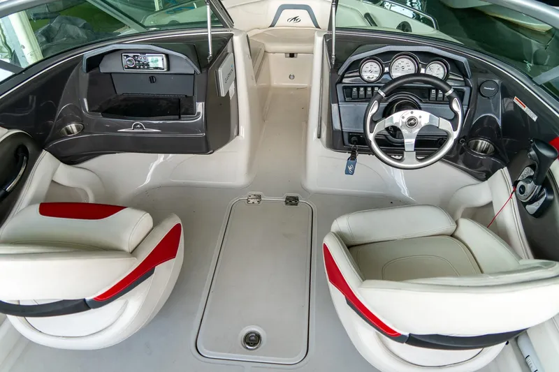 Slide: The Image of Interior of a 2013 Monterey 204FS boat with steering wheel and seating. - 12