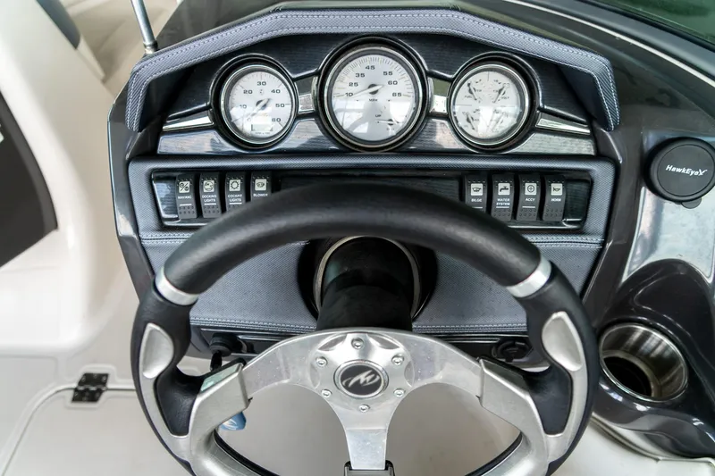 Slide: The Image of Steering wheel and dashboard of a 2013 Monterey 204FS boat with gauges and controls. - 13
