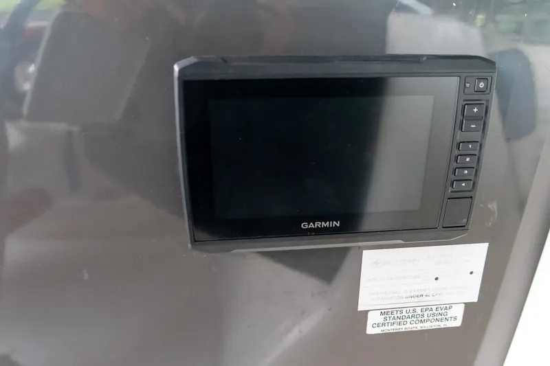 Slide: The Image of Garmin display on 2013 Monterey 204FS boat dashboard, featuring control buttons and EPA compliance label. - 14