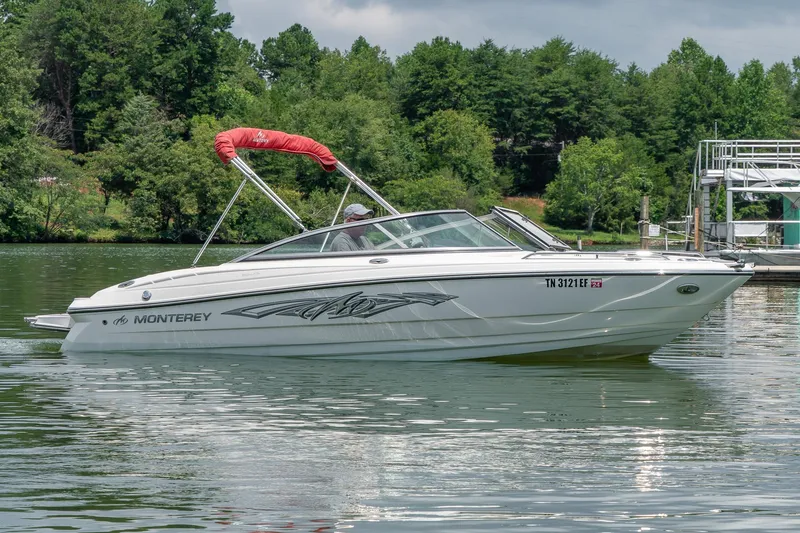 Slide: The Image of 2013 Monterey 204FS boat on a calm lake with lush green trees in the background. - 3