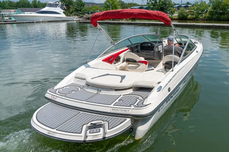 Slide: The Image of 2013 Monterey 204FS boat with red canopy cruising on a calm lake. - 6