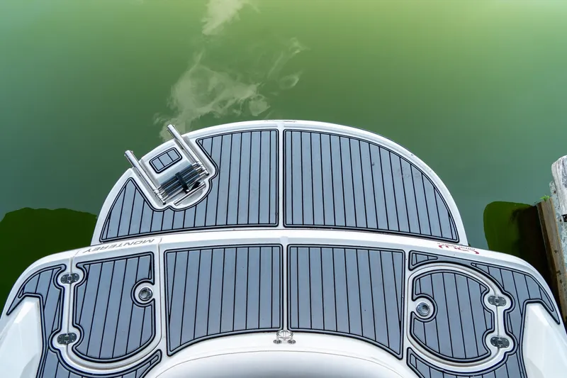 Slide: The Image of 2013 Monterey 204FS boat swim platform with ladder, docked on calm green water. - 8