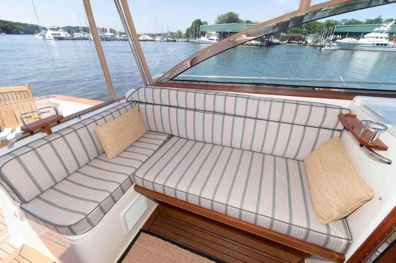 Slide: The Image of Cozy seating area on 1998 Sabre 36 Hardtop Express yacht with striped cushions and scenic marina view. - 10