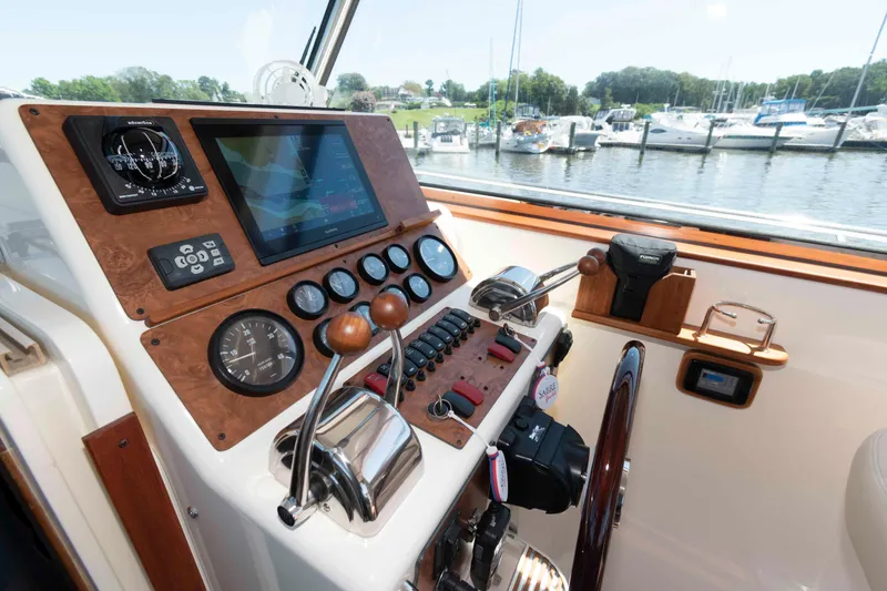 Slide: The Image of 1998 Sabre 36 Hardtop Express helm with navigation instruments and controls, docked at marina. - 12