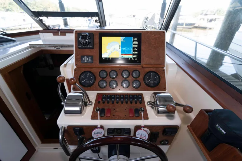 Slide: The Image of 1998 Sabre 36 Hardtop Express helm with navigation controls and display screen. - 13