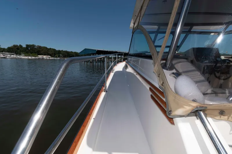Slide: The Image of Sabre 36 Hardtop Express 1998 yacht, docked by calm waters, showcasing sleek design and railing. - 17