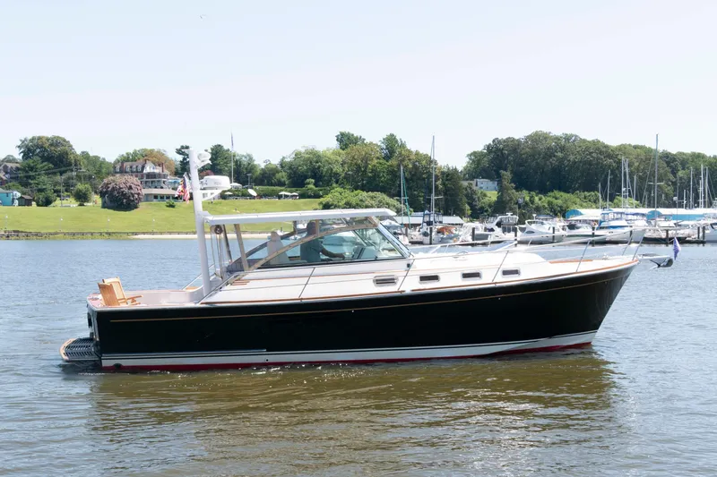 Slide: The Image of 1998 Sabre 36 Hardtop Express yacht on calm water near marina. - 2