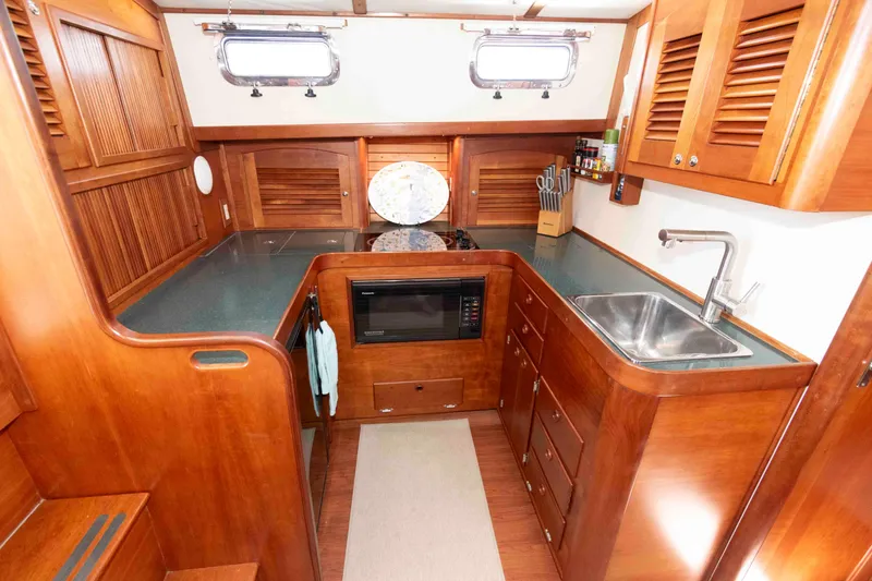 Slide: The Image of 1998 Sabre 36 Hardtop Express yacht kitchen with wood cabinetry and modern appliances. - 22