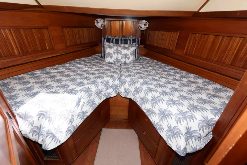 Slide: The Image of Cozy cabin interior of 1998 Sabre 36 Hardtop Express with palm-patterned bedding. - 24