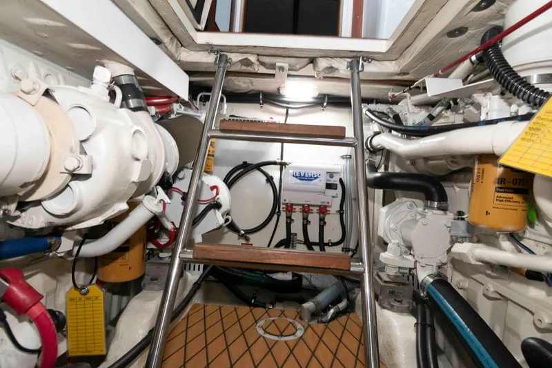 Slide: The Image of Engine room of 1998 Sabre 36 Hardtop Express with visible machinery and ladder. - 29