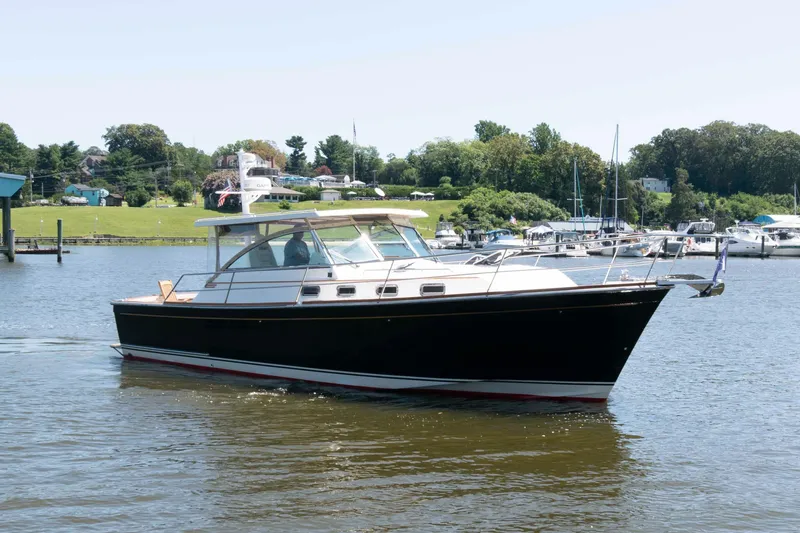 Slide: The Image of 1998 Sabre 36 Hardtop Express yacht cruising on a calm river near a marina. - 3