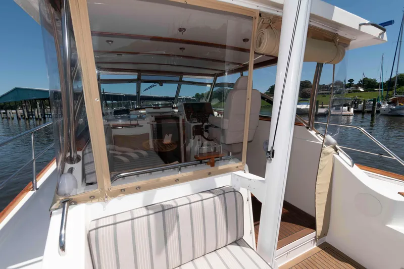 Slide: The Image of 1998 Sabre 36 Hardtop Express boat interior with striped seating and clear enclosure. - 8