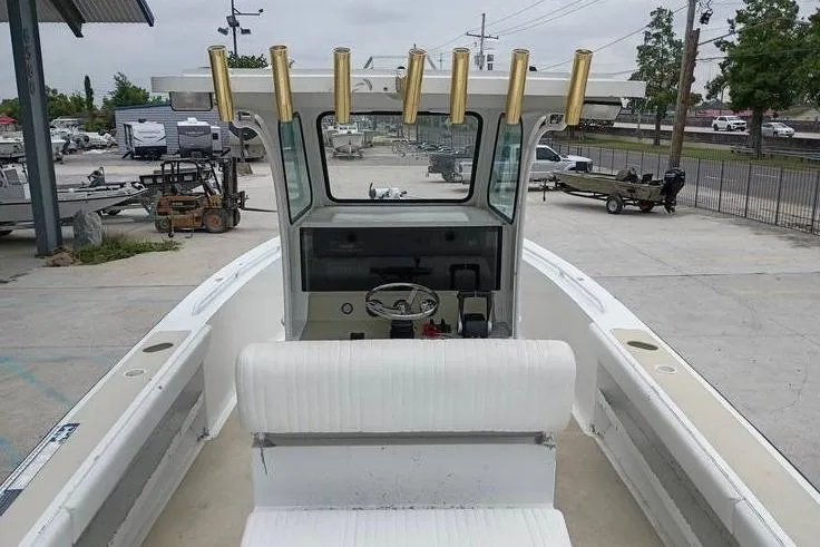 Slide: The Image of 2005 INTIMIDATOR 32 CC boat with center console and rod holders in a marina setting. - 10