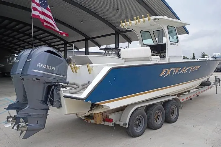 Slide: The Image of 2005 INTIMIDATOR 32 CC boat with Yamaha engines, on a trailer, under a covered dock. - 3