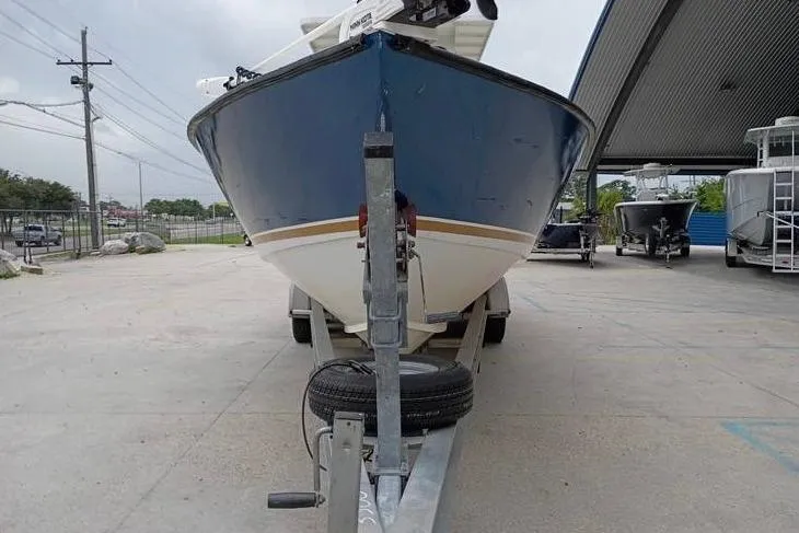 Slide: The Image of 2005 INTIMIDATOR 32 CC boat on trailer, parked outdoors under a canopy. - 7