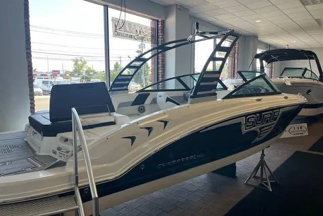 The Image of 2025 Chaparral 23 Surf boat displayed in showroom, featuring sleek design and modern features. - 1