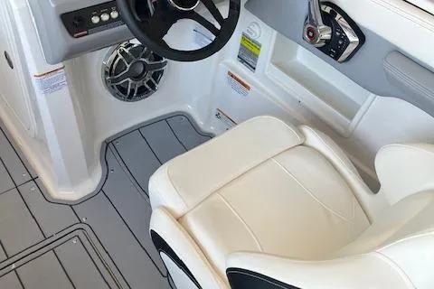 Slide: The Image of 2025 Chaparral 23 Surf boat interior with steering wheel and white seating. - 8