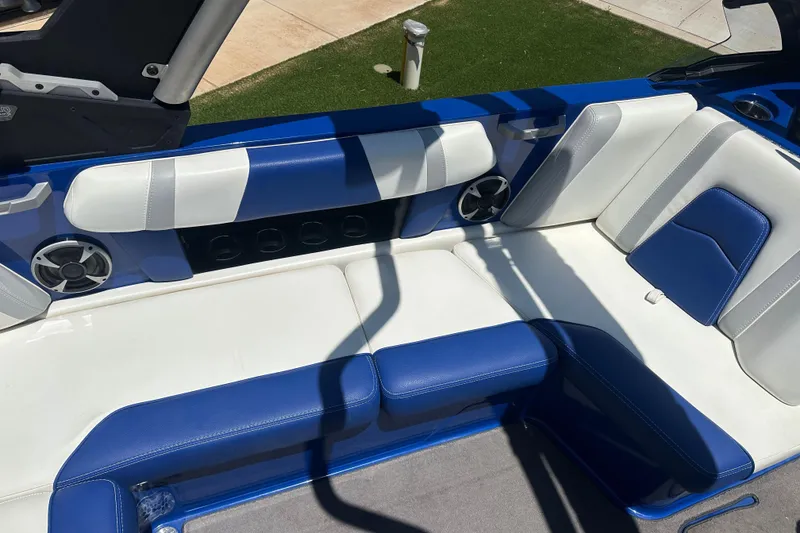 Slide: The Image of 2021 Malibu Wakesetter 21 MLX interior with blue and white seating and speakers. - 15