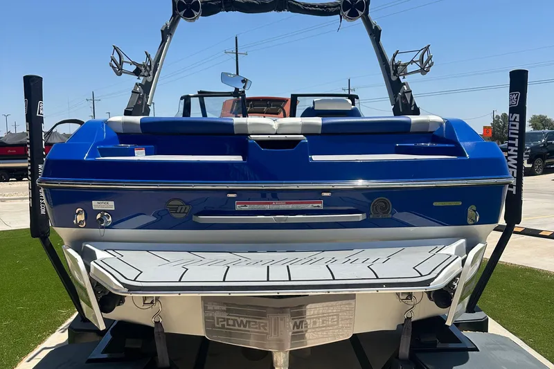 Slide: The Image of 2021 Malibu Wakesetter 21 MLX boat, blue exterior, rear view, on display outdoors. - 4