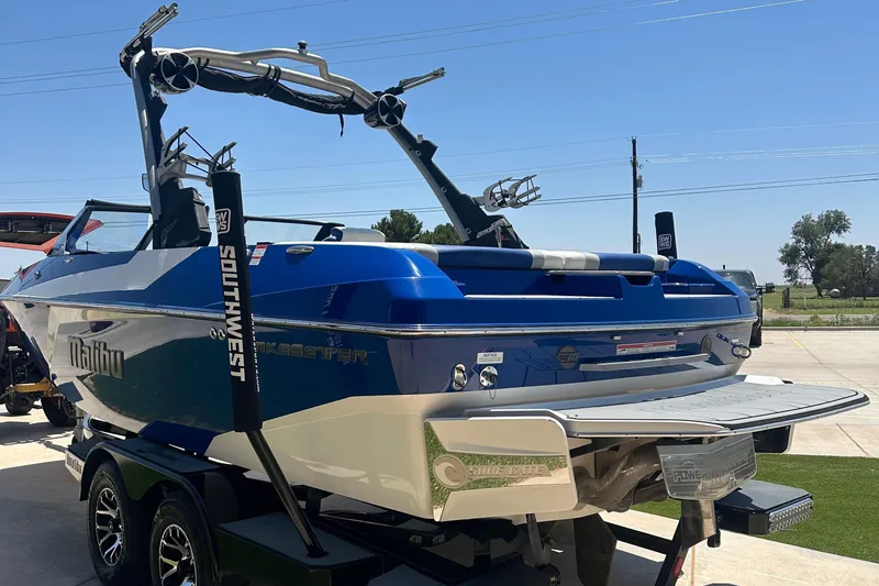Slide: The Image of 2021 Malibu Wakesetter 21 MLX boat in blue, parked on a trailer. - 5