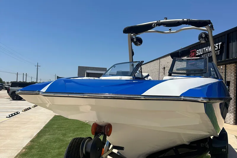Slide: The Image of 2021 Malibu Wakesetter 21 MLX boat in blue and white, displayed outdoors. - 8