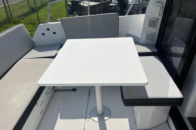 Slide: The Image of Outdoor seating area on a 2020 Jeanneau NC 895 boat with a white table. - 13