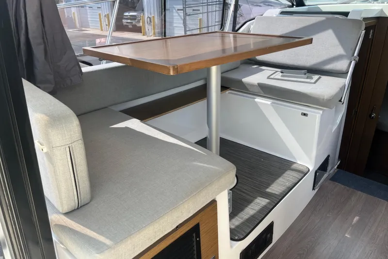 Slide: The Image of Interior seating area of 2020 Jeanneau NC 895 boat with table and cushions. - 15