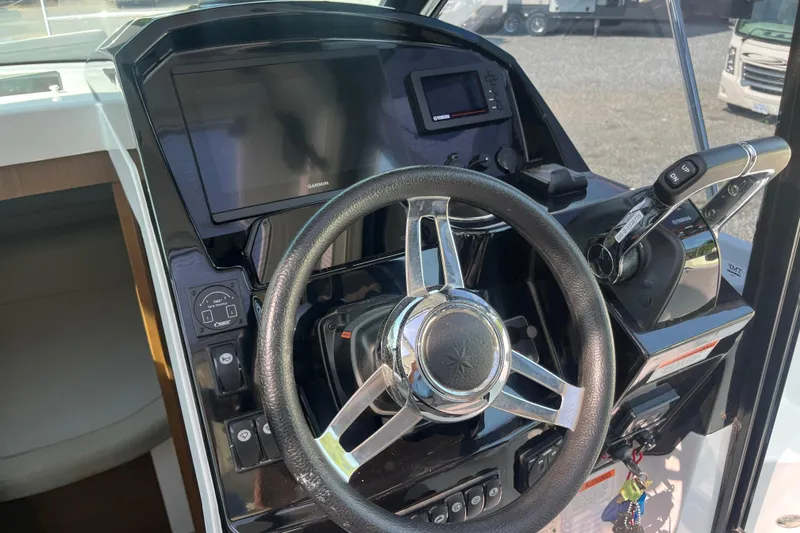 Slide: The Image of Steering wheel and controls of 2020 Jeanneau NC 895 boat cockpit. - 20