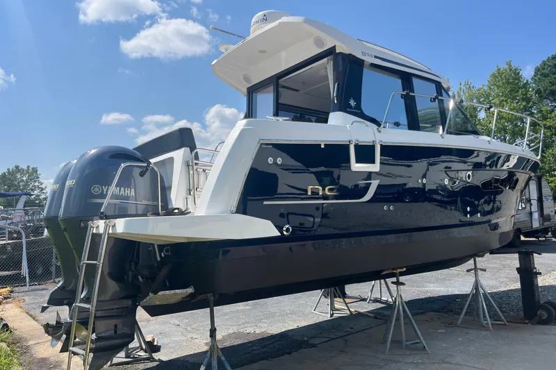 Slide: The Image of 2020 Jeanneau NC 895 boat with Yamaha engines on stands, under a clear blue sky. - 3