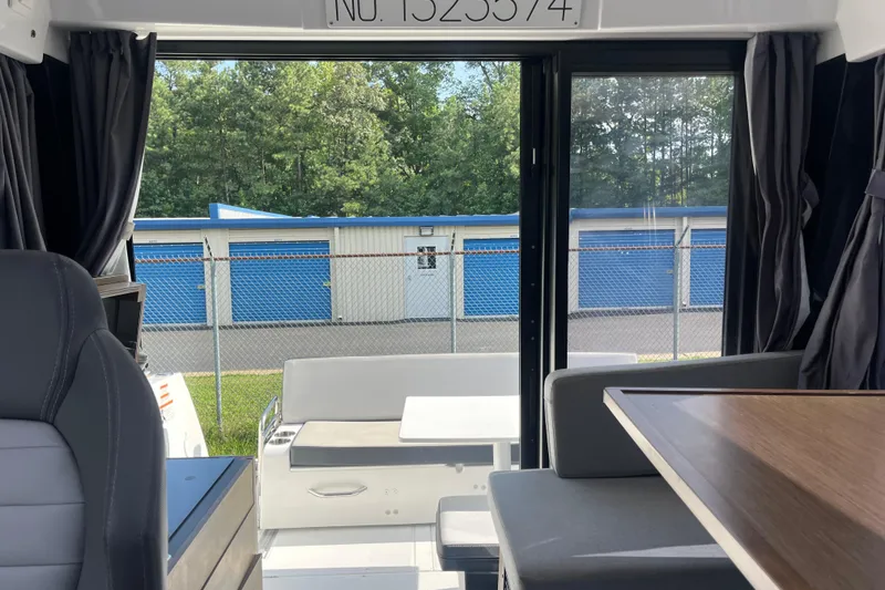 Slide: The Image of Interior view of 2020 Jeanneau NC 895 boat with seating and table, overlooking storage units. - 30