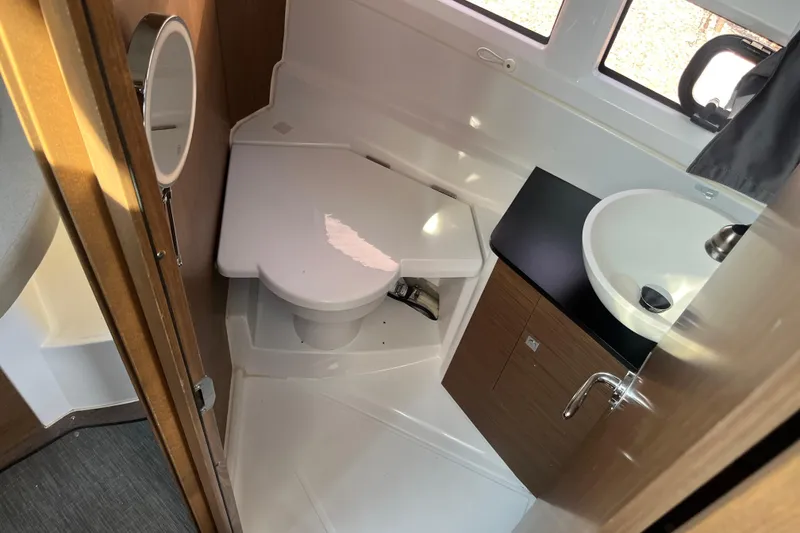 Slide: The Image of 2020 Jeanneau NC 895 boat bathroom with toilet, sink, and wooden cabinetry. - 35