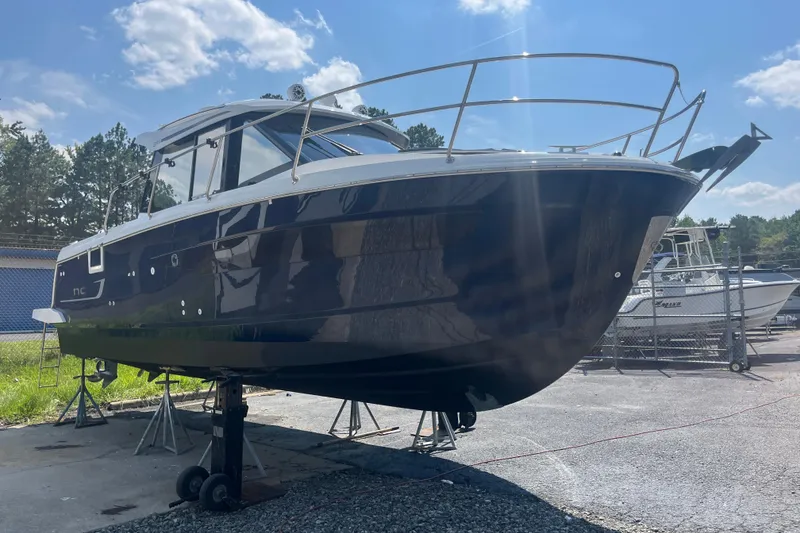 Slide: The Image of 2020 Jeanneau NC 895 boat on stands, outdoors under a clear sky. - 4