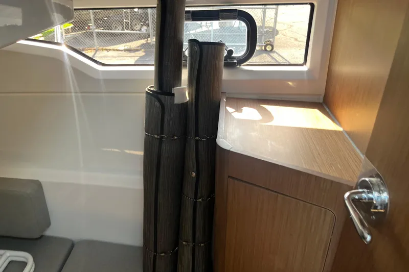 Slide: The Image of Interior of 2020 Jeanneau NC 895 boat with window, seating, and wooden cabinetry. - 42
