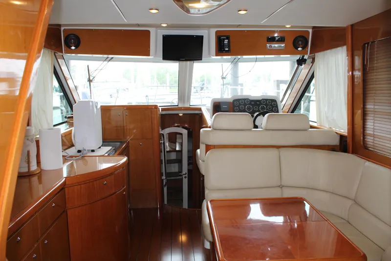 Slide: The Image of Interior of 2005 Beneteau Antares 13.80 yacht with wooden furnishings and white seating. - 10