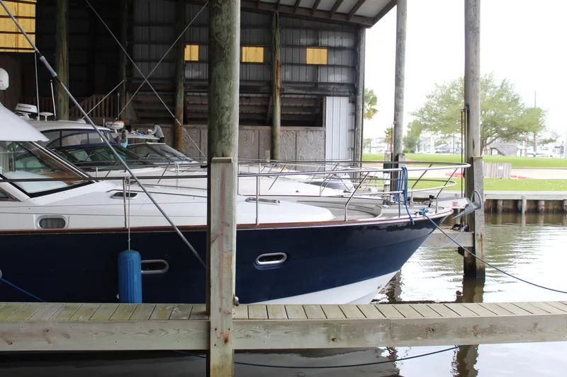 Slide: The Image of 2005 Beneteau Antares 13.80 docked in a covered marina. - 2