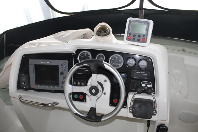 Slide: The Image of Control panel of a 2005 Beneteau Antares 13.80 boat with steering wheel and navigation instruments. - 36