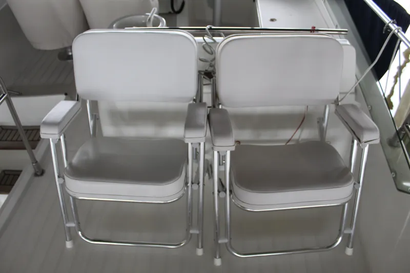Slide: The Image of Two white chairs on the deck of a 2005 Beneteau Antares 13.80 boat. - 43