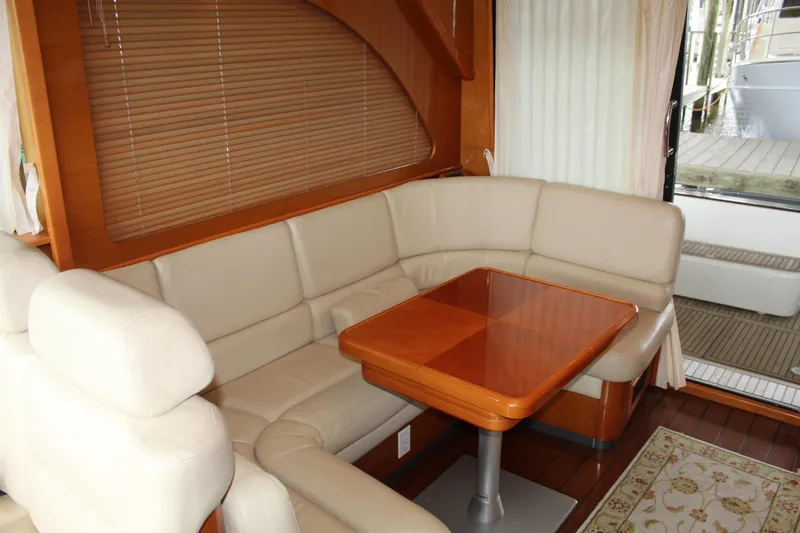 Slide: The Image of Interior of 2005 Beneteau Antares 13.80 with beige leather seating and wooden table. - 8