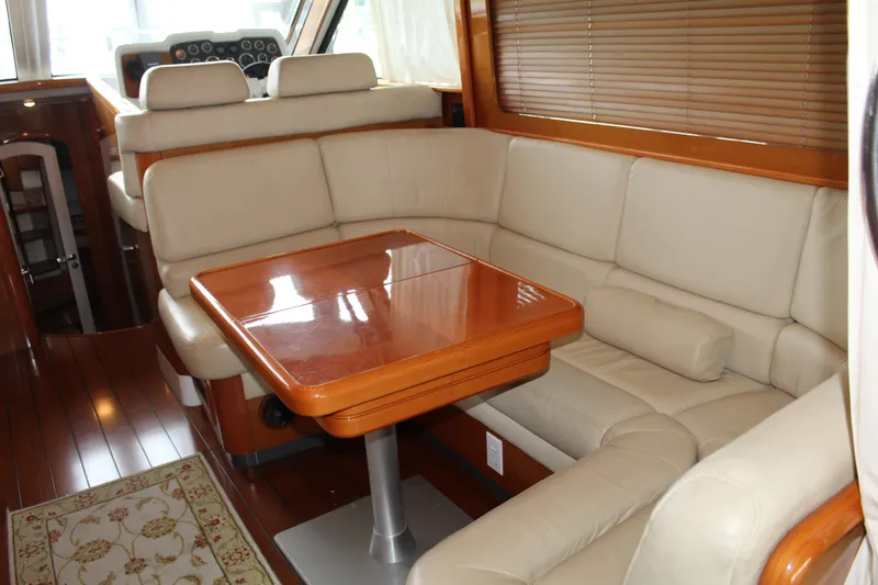 Slide: The Image of Interior of 2005 Beneteau Antares 13.80 with beige leather seating and wooden table. - 9