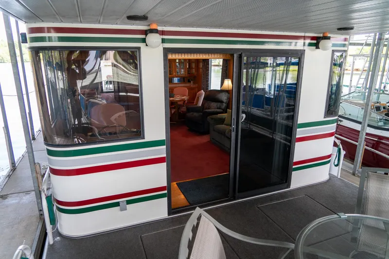 Slide: The Image of 1995 Lakeview 62 x 14 Widebody Houseboat with cozy interior and outdoor seating area. - 10