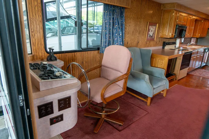 Slide: The Image of Interior of 1995 Lakeview 62 x 14 Widebody Houseboat with helm, chairs, and kitchen area. - 12
