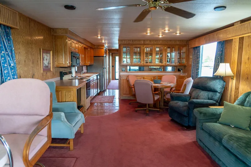 Slide: The Image of Interior of a 1995 Lakeview 62 x 14 Widebody Houseboat with cozy seating and wooden cabinetry. - 13