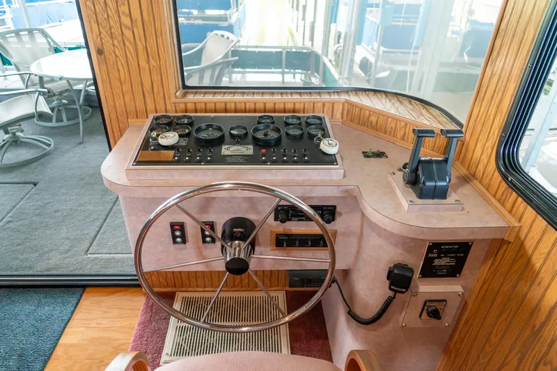 Slide: The Image of Control panel of a 1995 Lakeview 62 x 14 Widebody Houseboat, featuring steering wheel and gauges. - 17
