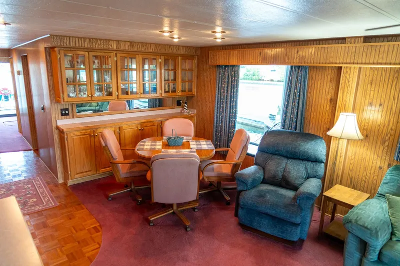 Slide: The Image of Interior of 1995 Lakeview 62 x 14 Widebody Houseboat with cozy seating and wooden cabinetry. - 20